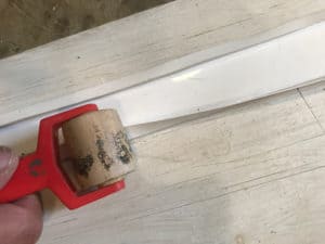 Using a wall paper roller to crease the plastic flashing for an arbor