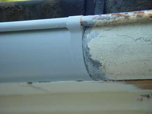 A closeup of gutters with peeling paint.